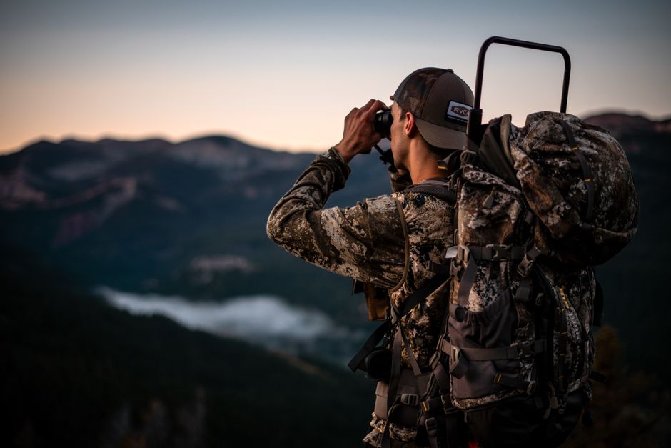 A photographer pausing at dusk, representing patience, attention, and deliberate observation.