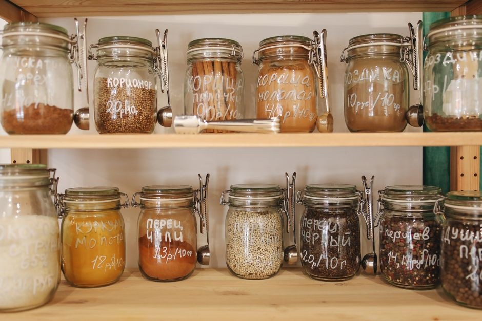 Glass jars of pantry staples arranged neatly on open shelves.