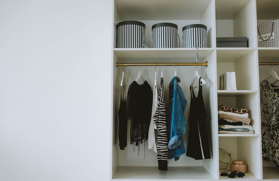 An orderly open wardrobe with clothes and storage arranged clearly.