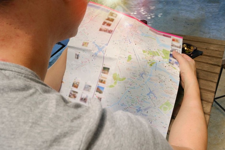 A traveler studies a folded city map, reflecting the journal’s focus on curious everyday exploration.